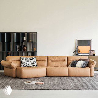 Угловой диван светло-коричневого оттенка в стильной гостиной, видно мягкие подушки и простую мебельную композицию.