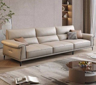 Бежевый кожаный диван в просторной гостиной на фоне светлой стены и низкого журнального столика, общий план для демонстрации формы и пропорций.