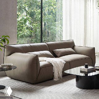 Диван Navola в кожаной обивке в светлой гостиной у панорамного окна, вид спереди с пледом на сиденье