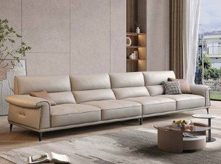 Широкий вид бежевого дивана в гостиной с ковром и журнальным столиком, показаны форма, пропорции и сочетание с интерьером, общий план.