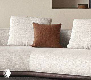 Крупный план коричневой декоративной подушки на светлом диване, контрастная деталь дизайна, подчёркивающая текстуру и цветовую гамму модели.