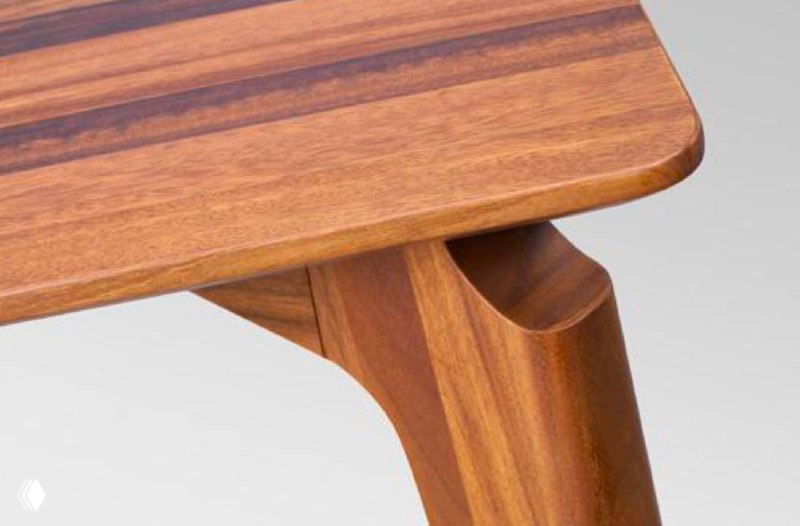 Крупный план соединения ножки и столешницы из южноамериканского ореха, видно качество обработки и текстуру древесины.
