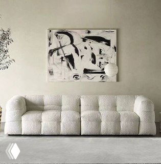 Белоснежный модульный диван с крупными округлыми пуфами и стёганой поверхностью в минималистичном интерьере, вид спереди и общий план