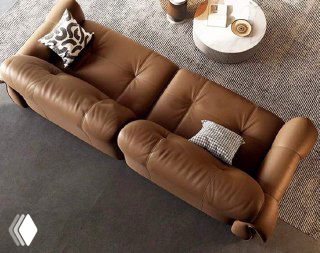 Вид сверху на коричневый кожаный диван: фактура обивки, мягкие подушки и форма сидений — акцент на конструктивных деталях и комфорте.