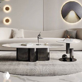 Овальный журнальный столик с белой натуральной каменной столешницей и черными металлическими опорами в светлом помещении.