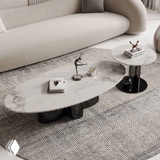 Круглый и овальный журнальные столики с мраморными столешницами и глянцевыми черными основаниями на ковре возле дивана.
