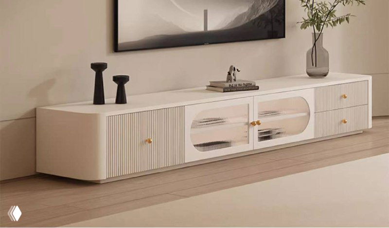 Крупный план белой ТВ тумбы со стеклянными дверцами и декоративными рельефными фасадами в современном интерьере с деревянным полом.