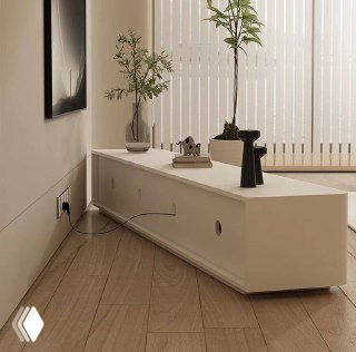 Вид сзади на низкую ТВ тумбу: отверстия для проводки, ровная задняя панель и расположение мебели в комнате рядом с розеткой и шторами.