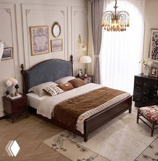 Крупный план кровати в реальной комнате: ковёр, постельные текстуры и гармоничная цветовая палитра вокруг деревянной мебели.