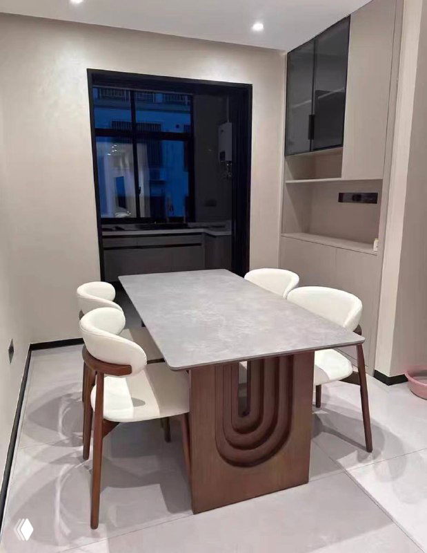 Фотография установленного обеденного стола в реальной кухне: столешница тёплого древесного оттенка и белые стулья вокруг, контекст жилого интерьера.