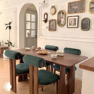 Альтернативный интерьер с другим вариантом обеденного стола и зелёными бархатными стульями, демонстрирующий возможные сочетания отделки и материалов.