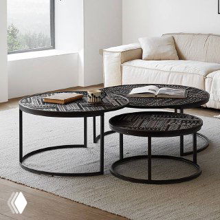 Три круглых журнальных столика с тёмной резной столешницей и чёрным металлическим каркасом на ковре у дивана.