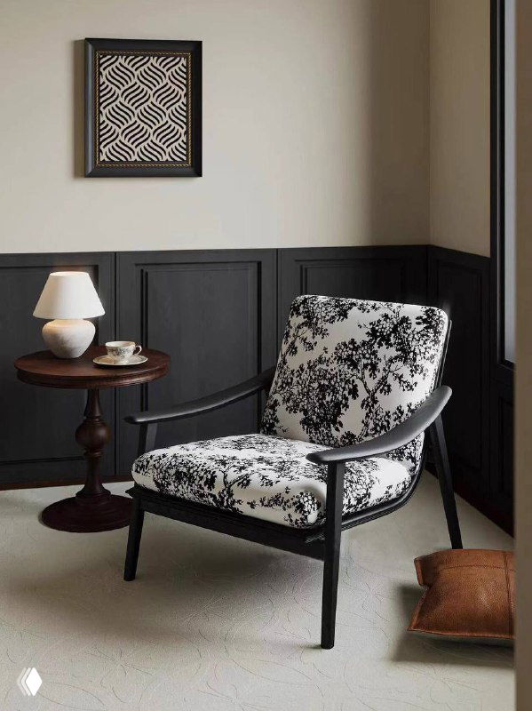 Кресло из ясеня в светлом интерьере: темный деревянный каркас и светлая тканевая обивка с контрастным ботаническим узором, общий вид сиденья и окружения.