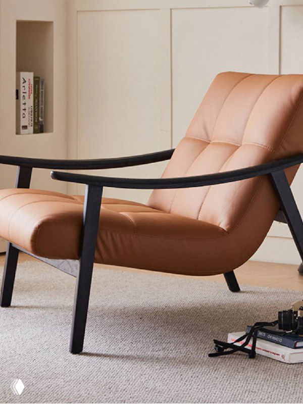 Кресло из ясеня в кожаном варианте светло‑коричневой кожи; общий вид спереди, демонстрация объёма сиденья и мягкой набивки на фоне интерьера.