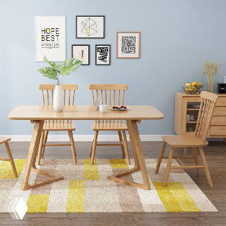 Обеденный стол из светлого массива и деревянные стулья в уютном интерьере; ракурс показывает столешницу, ножки и часть ковра.