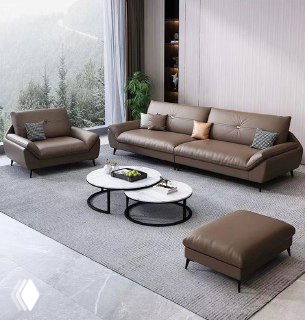 Интерьер: коричневый кожаный диван с креслом и пуфом на сером ковре у большого окна; круглые столики.