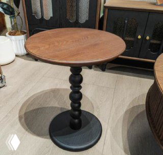 Круглый журнальный столик из ясеня на фигурной резной ножке и круглом основании, показан в комнате на светлом полу.
