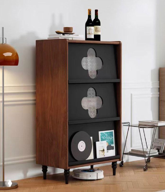 Комод из ясеня в интерьере: высокий узкий шкаф с тёмными фасадами и декоративными вырезами, винил, книги на полках и бутылки на верхней поверхности