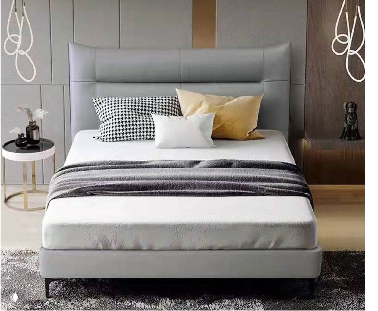 Серая мягкая кровать с высоким обитым изголовьем, белым и горчичным текстилем, покрывалом и тумбой в уютном интерьере спальни