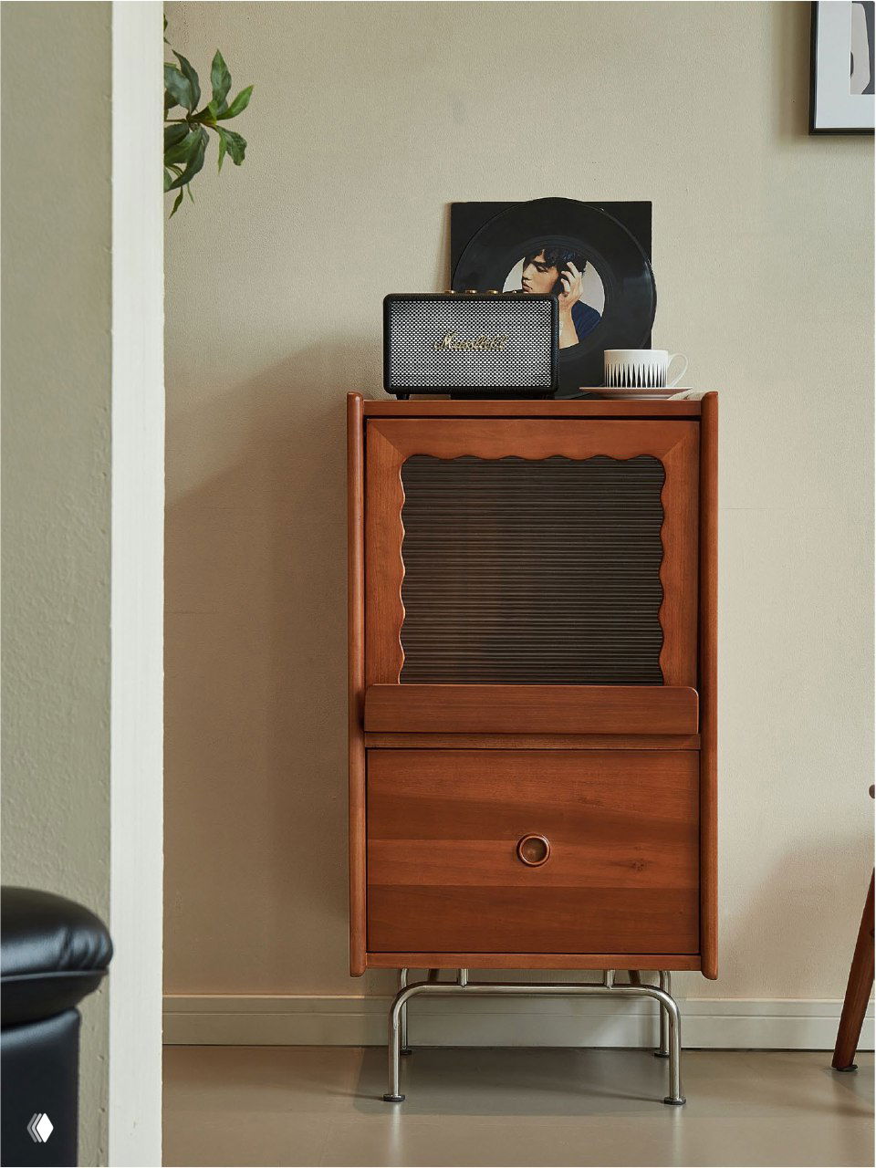 Комод из массива ясеня в интерьере: узкий шкаф с роллетой, выдвижным ящиком и металлическими ножками на светлой стене.