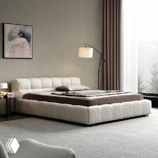 Мягкая низкая кровать в светлом минималистичном интерьере: белая текстильная обивка, торшер, картина и большое окно на фоне.