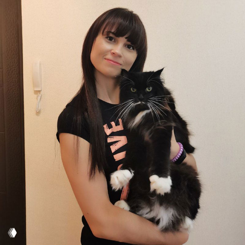 Женщина-психолог держит на руках большого черно-белого кота в домашней обстановке; лицо автора видно, кот крупный и пушистый.