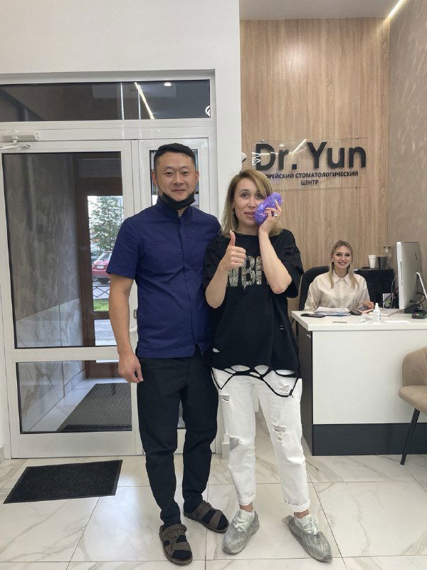 Два человека в холле клиники на фоне ресепшн с логотипом «Dr. Yun» — фотография из визита команды агентства в медицинский центр, демонстрирующая офисную атмосферу.