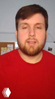 Кадр из видео: преподаватель канала в красной футболке объясняет подход к системной подготовке к ОГЭ; видна стена и предметы кабинета на заднем плане.