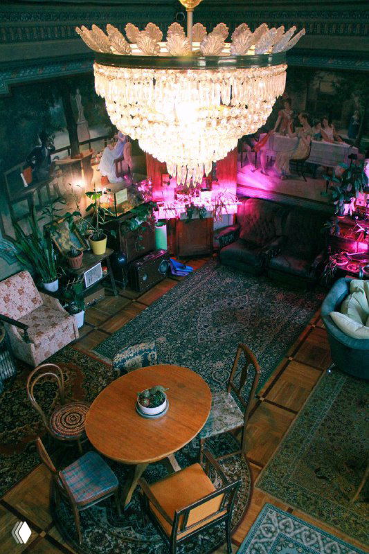 Вид сверху на бальный зал с круглым столом, зоной бара и разноцветной подсветкой, создающей перформативную атмосферу вечера.