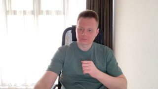 Портрет мужчины в футболке за рабочим столом в светлой комнате; нейтральный деловой кадр, подходит для материала о найме.