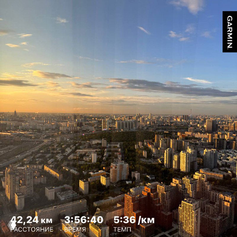 Панорамный вид города с высоты на закате; внизу видны здания и подпись Garmin с данными пробежки: 24 км, 3:56:40, 5:36/км.