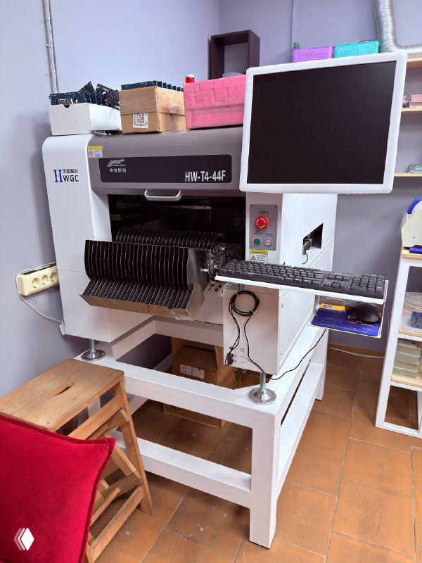 Промышленное оборудование с монитором и системой автоматической подачи компонентов для сборки электронных модулей и плат.