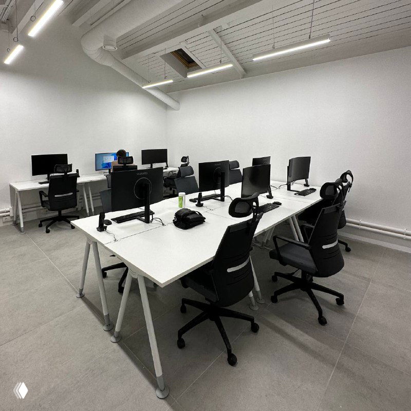 Пустой офис с белыми столами, мониторами и офисными креслами — изображение рабочего пространства, иллюстрирующее тему найма сотрудников.