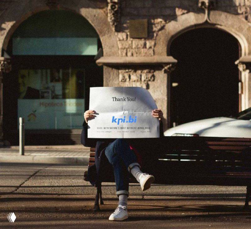 Человек на скамейке держит лист с надписью «kpi.bi», на фоне городская улица и размытые проезжающие машины — иллюстрация к подборке статей.