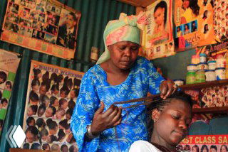 Небольшая парикмахерская в Мьяичине, Мьянма: внутренняя обстановка, постеры с образами и деревянная конструкция салона в сельской местности.