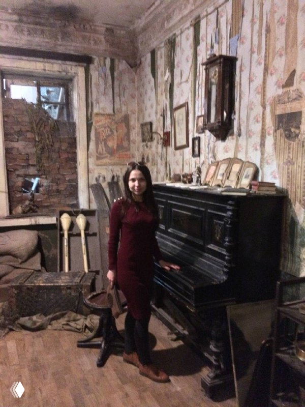 Автор в историческом интерьере с пианино и старинными предметами: домашняя сцена, музейная воссозданная комната.