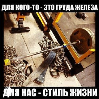 Штанга с блинами, тяжёлыми цепями и тренировочным поясом, оставленная на полу в тренажёрном зале рядом со стойкой; мотивационная атмосферная фотография о спорте и привычках