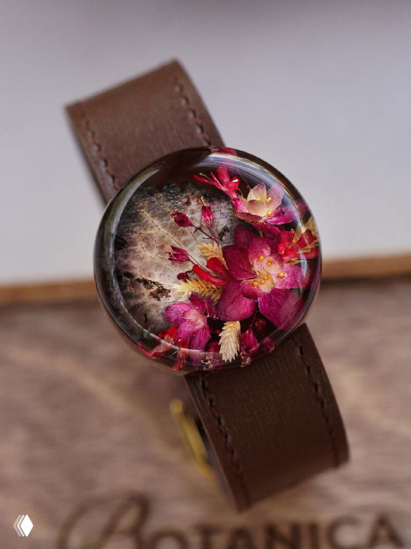 Прозрачный кабошон в браслете с насыщенными розово-бордовыми засушенными цветами и текстурным фоном — пример осенней композиции для украшений из смолы.