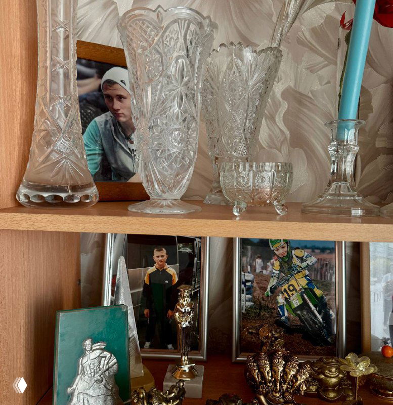 Полка с хрустальными вазами, семейными фотографиями и спортивными кубками — домашняя витрина воспоминаний и достижений в родительском доме.