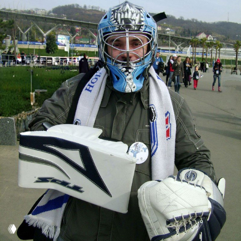 Портрет человека в вратарской маске и спортивной экипировке в Олимпийском парке, держащего перчатки и атрибутику — фанатский образ и эмоции.