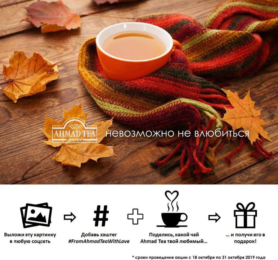 Промо‑картинка Ahmad Tea: чашка чая на деревянном столе в шарфе и осенними листьями; внизу пиктограммы акции с хэштегом и обещанием подарка.