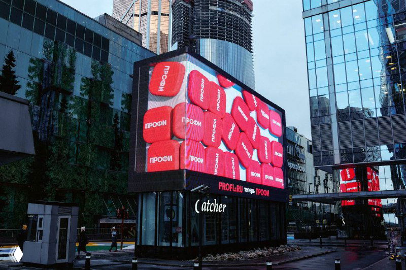 Большой LED-экран в центре Москвы с новым красным логотипом и фирменными элементами ребрендинга сервиса «Профи», размещённый в городской среде.