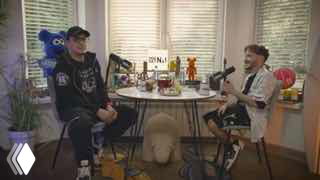 Кадр подкаста: двое ведущих сидят за круглым столом в студии, на столе микрофоны, напитки и реквизит — беседа о блогерах ВК.