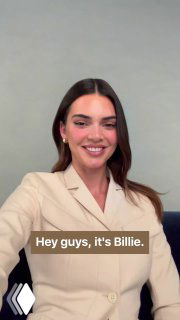 Женщина в бежевом пиджаке улыбается на нейтральном фоне; на кадре видна англоязычная подпись «Hey guys, it's Billie.» — демонстрация ролика с чат‑ботом.