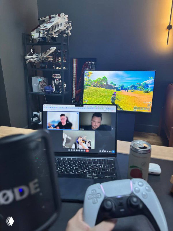 Фотография рабочего стола во время записи подкаста: монитор с Fortnite, ноутбук на видеозвонке, контроллер и микрофон.