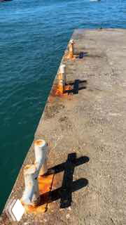 Кадр с пирсом и морской водой: стоп-кадр с причалом и металлическими швартовами, создающий атмосферу «снимали случайно» в ролике.