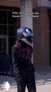 Кадр из ролика: человек на улице в шлеме Венома, поверх кадра белый текст POV и подпись про поход смотреть Venom; скриншот TikTok с уличным фоном.