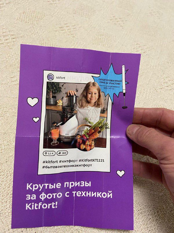 Фиолетовый вкладыш с имитацией Instagram-поста: фото женщины на кухне и призы за фото с техникой Kitfort; лист сложен и держится рукой.