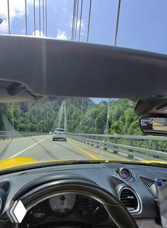 Дорожный кадр с открытым верхом автомобиля: вид на дорогу и окружающий пейзаж в стиле путешествия, съёмка через очки в движении.