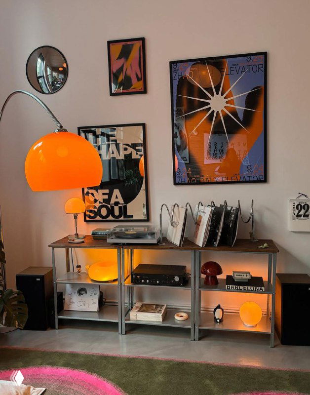 Настенная композиция из плакатов над системой хранения и лампой: фото демонстрирует как плакаты вписываются в домашний декор.